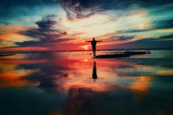 silhouette-of-person-standing-on-rock-surrounded-by-body-of-water.jpg silhouette of person standing on rock surrounded by body of water